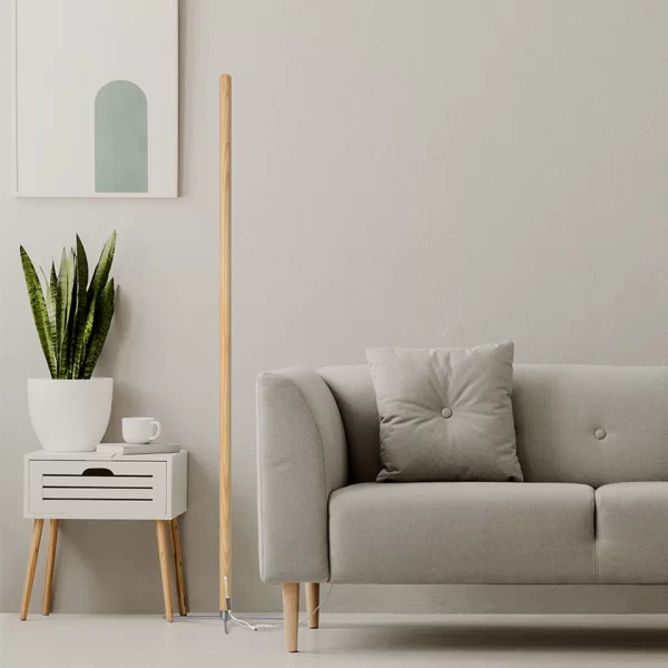 To the left of the gray sofa stands a modern LED ash wood floor lamp.