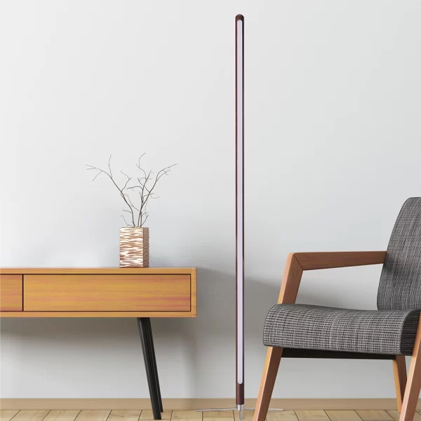 Between the yellow table and gray chair stands a black walnut floor lamp.