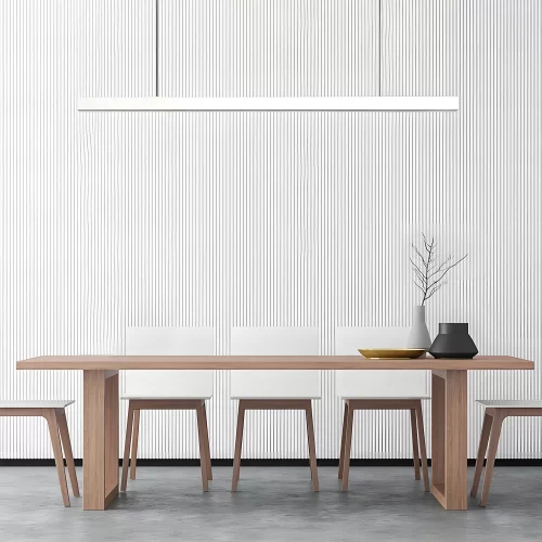 A white pendant light hangs above a wooden dining table in front of a linear ripple-patterned background.