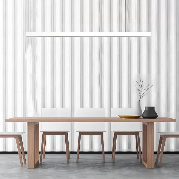 A white pendant light hangs above a wooden dining table in front of a linear ripple-patterned background.