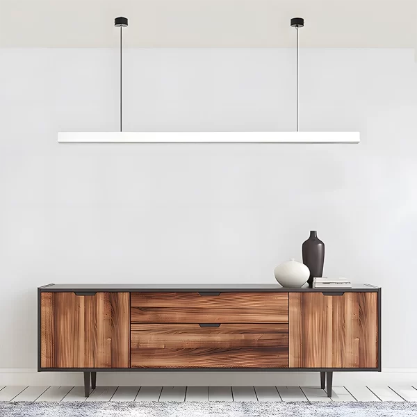 A linear white pendant light hangs above a black walnut wood TV cabinet.