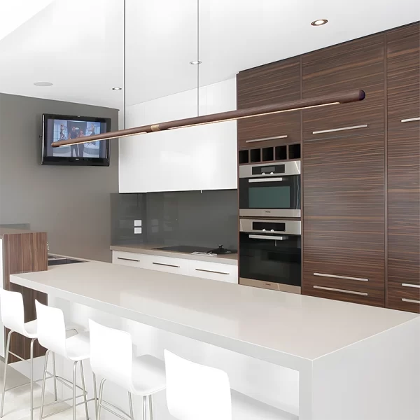 A 2.2m black walnut pendant hangs above a white dining table in the kitchen, with four white chairs on one side.