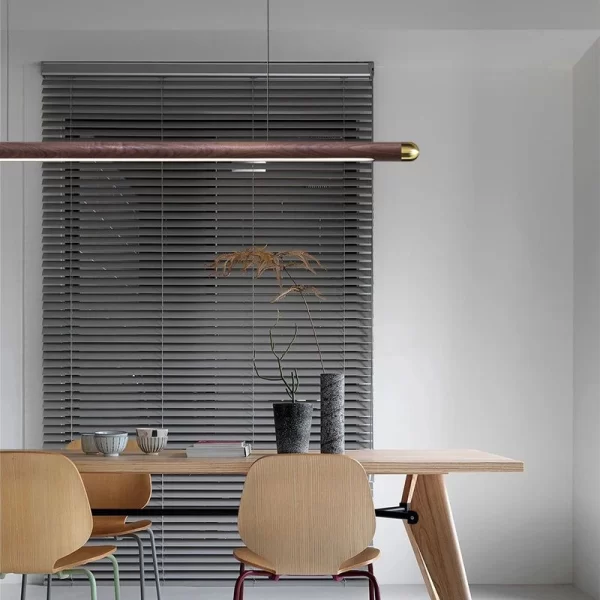 A linear round rod pendant light hangs above a table in the meeting room.