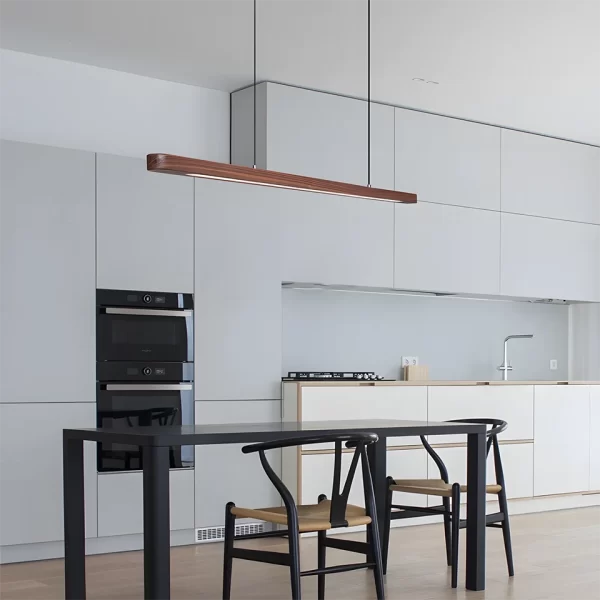 Minimalist black walnut pendant light hangs above the black kitchen dining table.