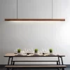 A black walnut pendant light hangs above a table set with dinnerware.