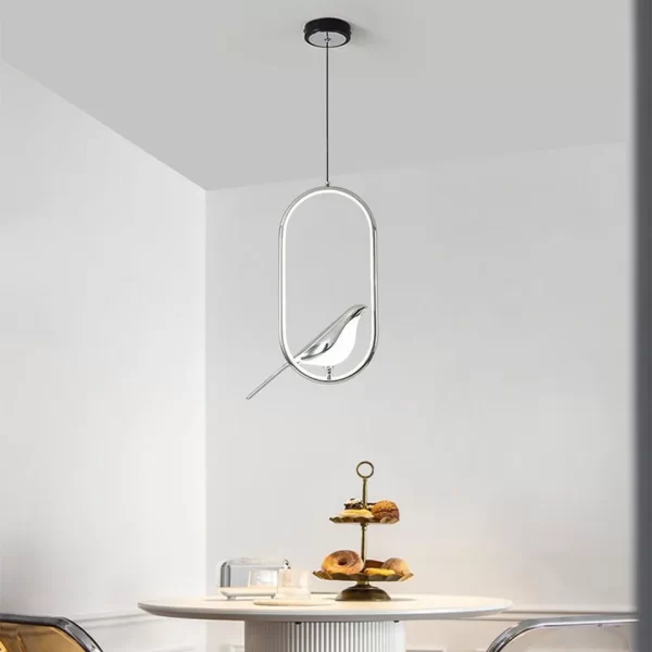 Oval Silver Creative Magpie Bird Rotatable LED Chandelier hangs from the ceiling above the dining table.