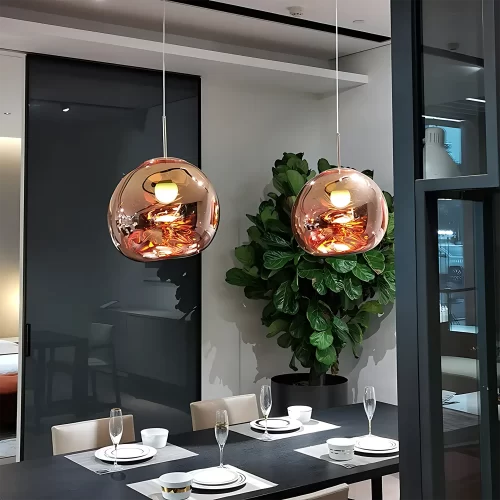 Two shining Rose Gold Irregular Lava Glass Pendants Light hangs from the ceiling above the dinner table.