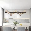 Modern Glass Sphere Chandelier Light Hangs Elegantly above the white dining table in the kitchen， Adding a touch of modern luxury atmosphere.