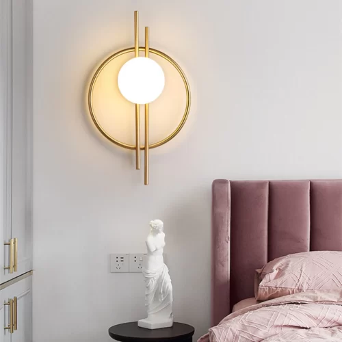 Golden circular acrylic wall lamp at the bedside