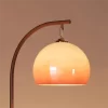 Close up of Retro Tall Pole Arc Floor Lamp, displaying the orange glass lampshade.