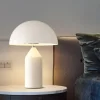 On the bedside table stands a White Color Modern Mushroom LED Table Lamp emitting neutral light.